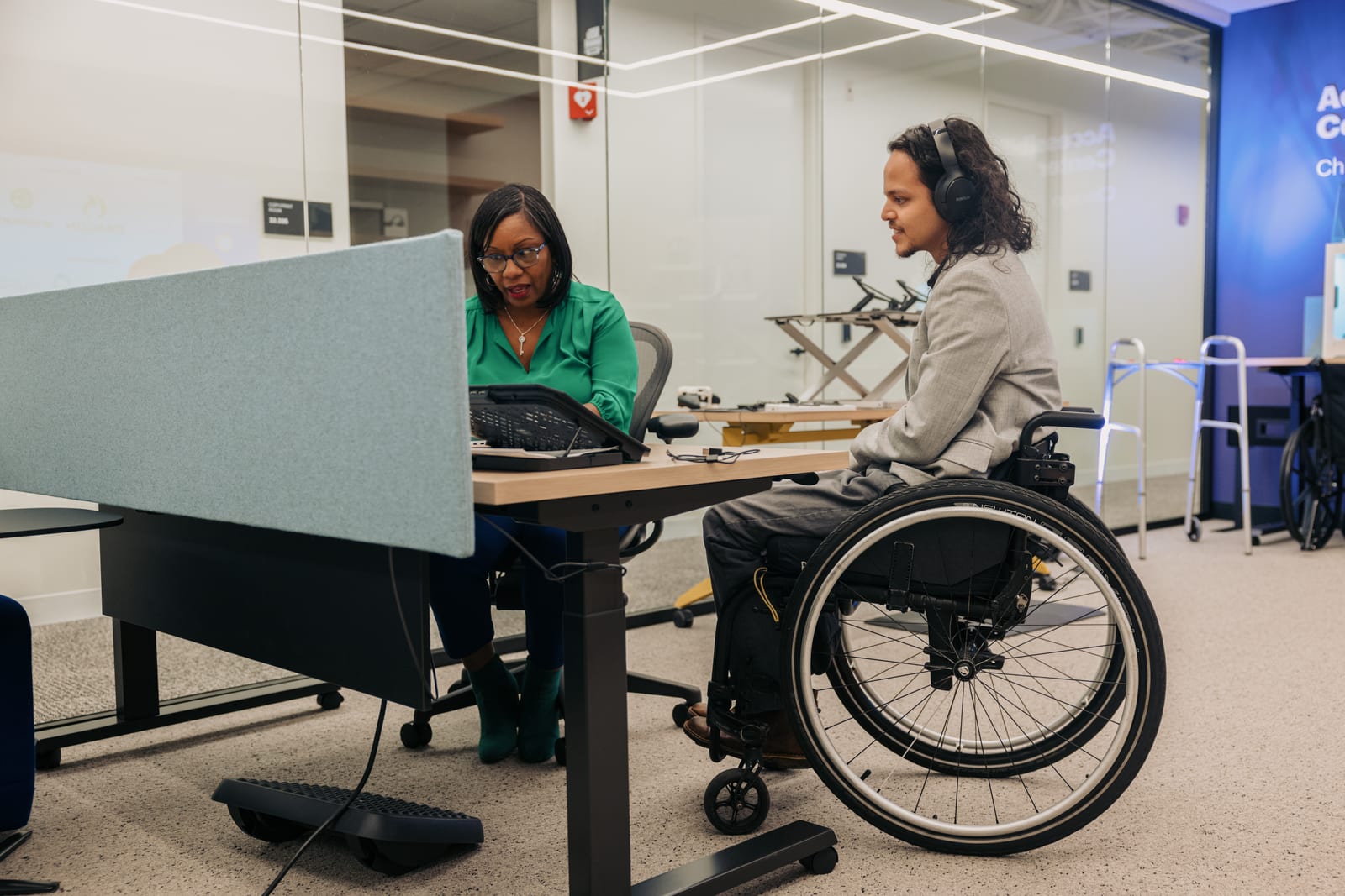 Two colleagues collaborating in an accessibility solutions center, demonstrating the power of Thrive Assist.